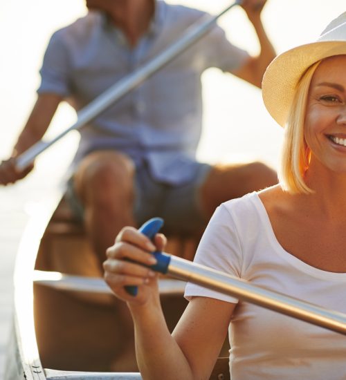 Smiling young woman canoeing with her boyfriend on a lake